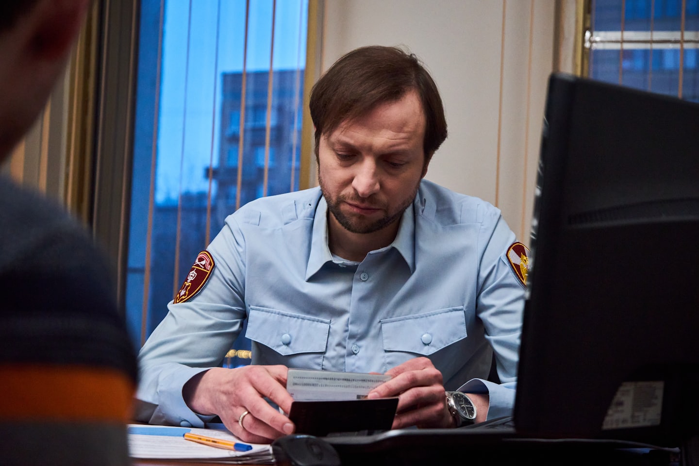 Een agent onderzoekt een document aan een bureau op kantoor.