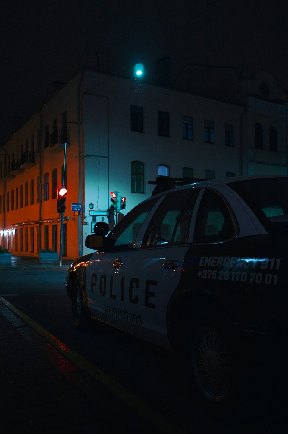 Politiewagen geparkeerd op een stadsplein.